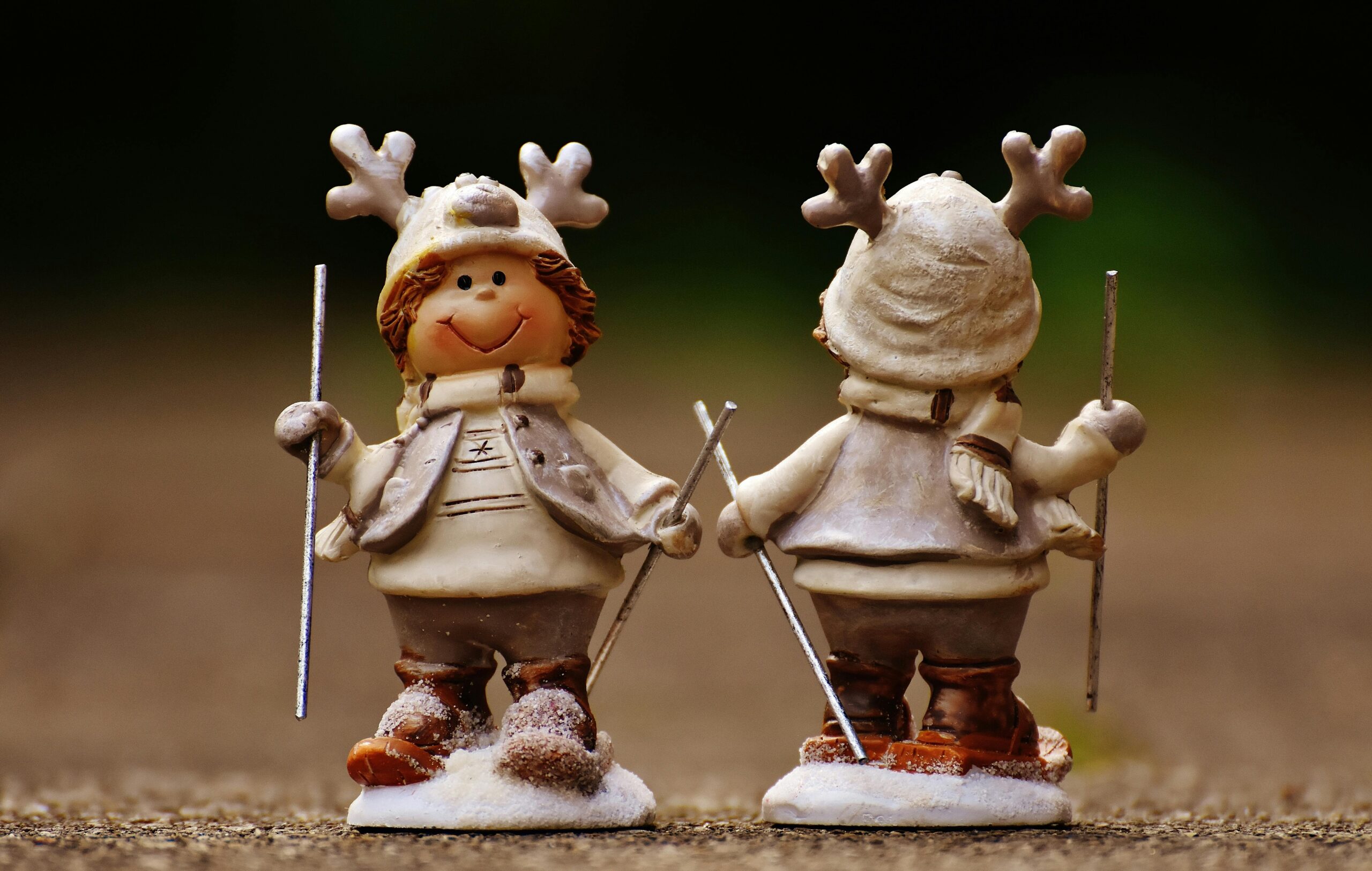 Charming winter figurines with antler hats holding ski poles, perfect for holiday decor.