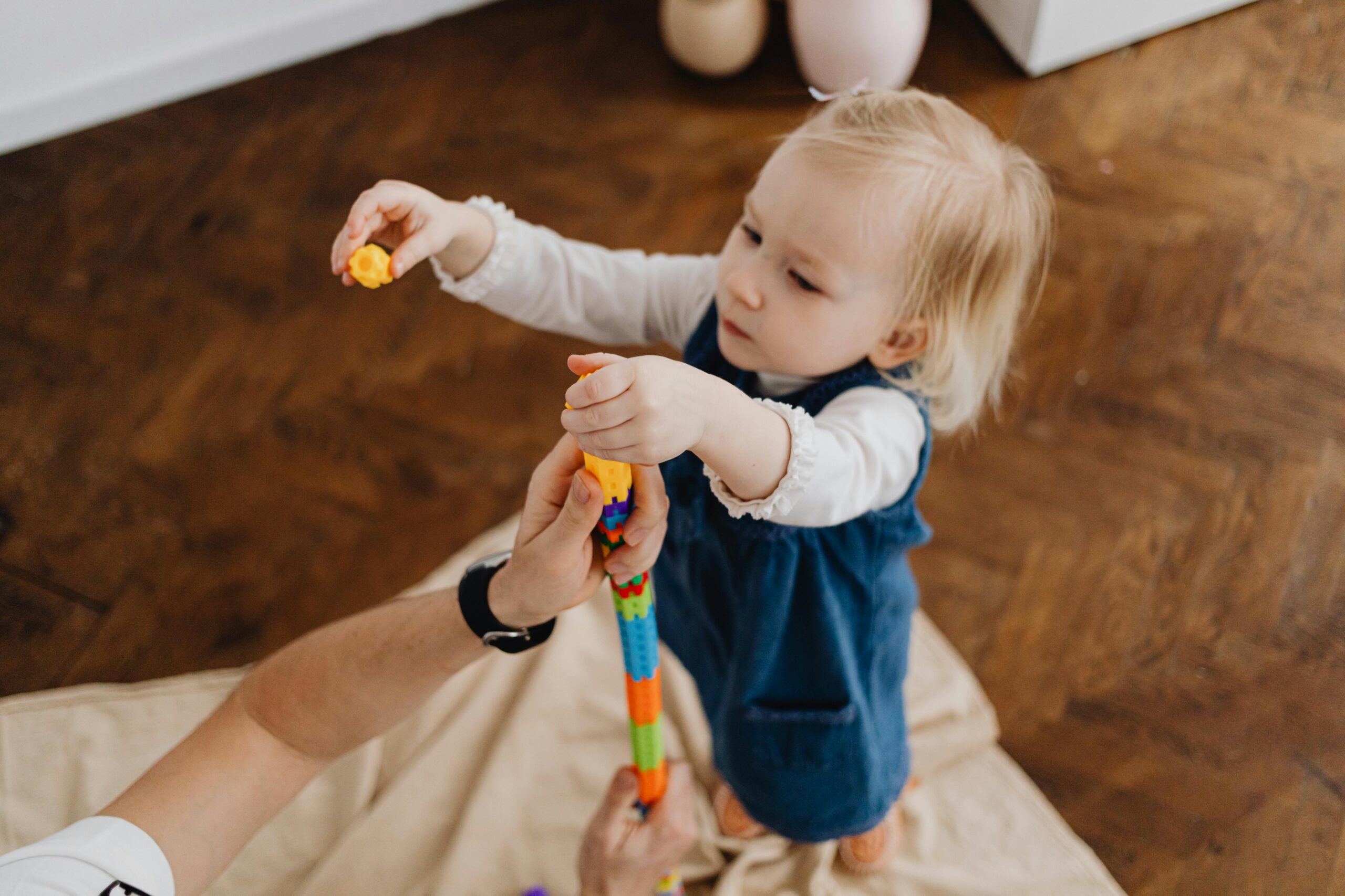 Adorable child playing with vibrant blocks indoors.