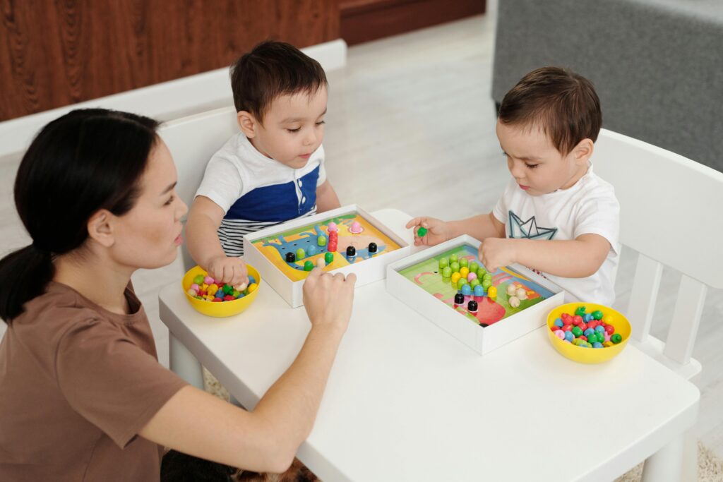 A mother and two young children enjoy a playtime session with colorful kids toys indoors.