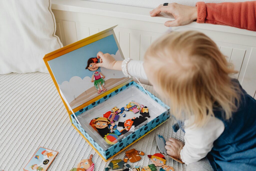 Young child playing with puzzles, a type of toddler toys, on a bed indoors, fostering creativity and learning.
