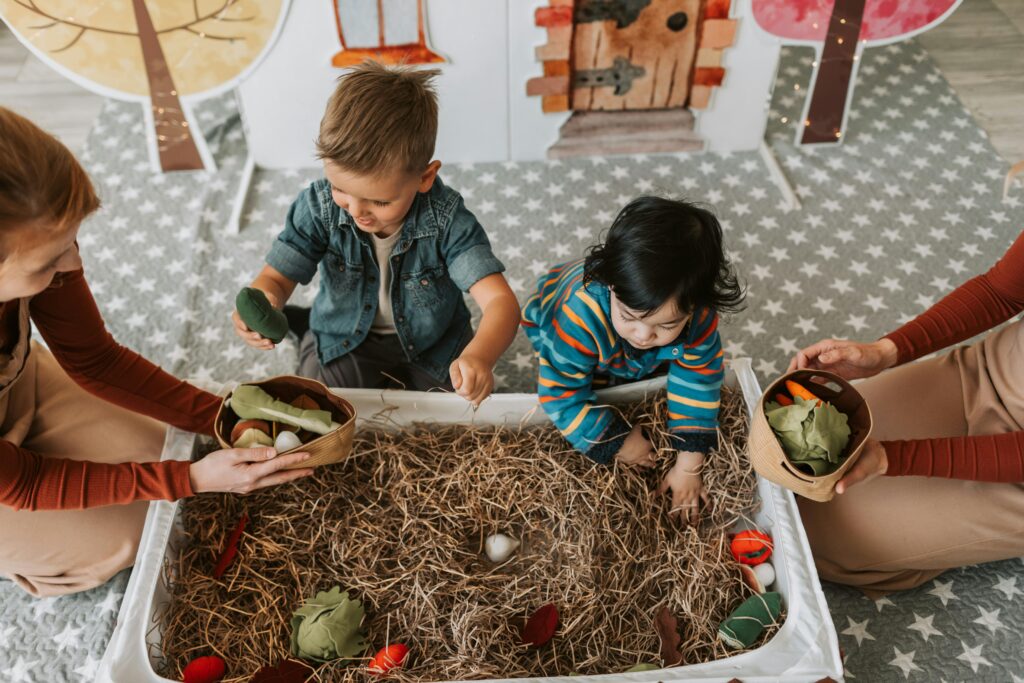 Children engaged in playful activities in a cozy indoor playroom full of toddler toys and imagination.